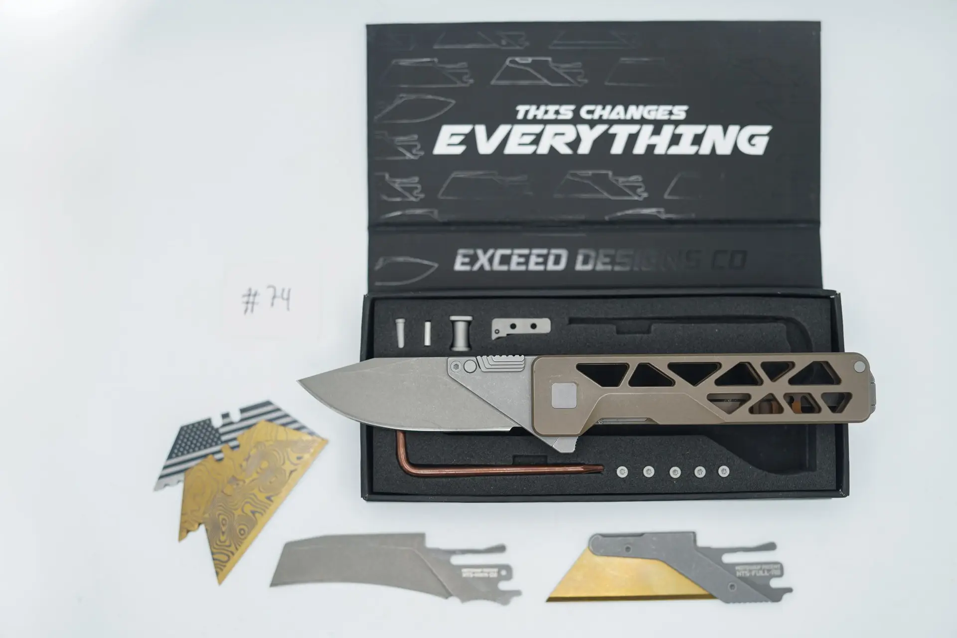 BUILD #74 — Condition 8/10 — TiRant ULTRA Skeleton ‘SKULTRA’ Centurion Bronze W/Blasted Grey Hardware + Original Box W/Spare Grey Blasted Hardware Kit / Lock Bar insert + D2 Hawkbill Hotswap Blade + D2 Stonewashed Drop Point Hotswap Blade + 3X Custom Laser Engraved Razor Blades
