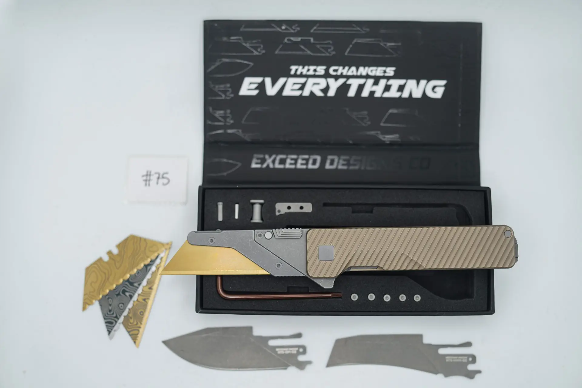 BUILD #75 — Condition 9/10 — TiRant ULTRA Deep-Slash DUAL Milled Centurion Light-Bronze – Minor Blem in ANO finish (See Photos) W/Blasted Grey Hardware + Original Box W/Spare Grey Blasted Hardware Kit / Lock Bar insert + D2 Stonewashed Hawkbill Hotswap Blade + D2 Stonewashed Drop Point Hotswap Blade + 3X Custom Laser Engraved Razor Blades