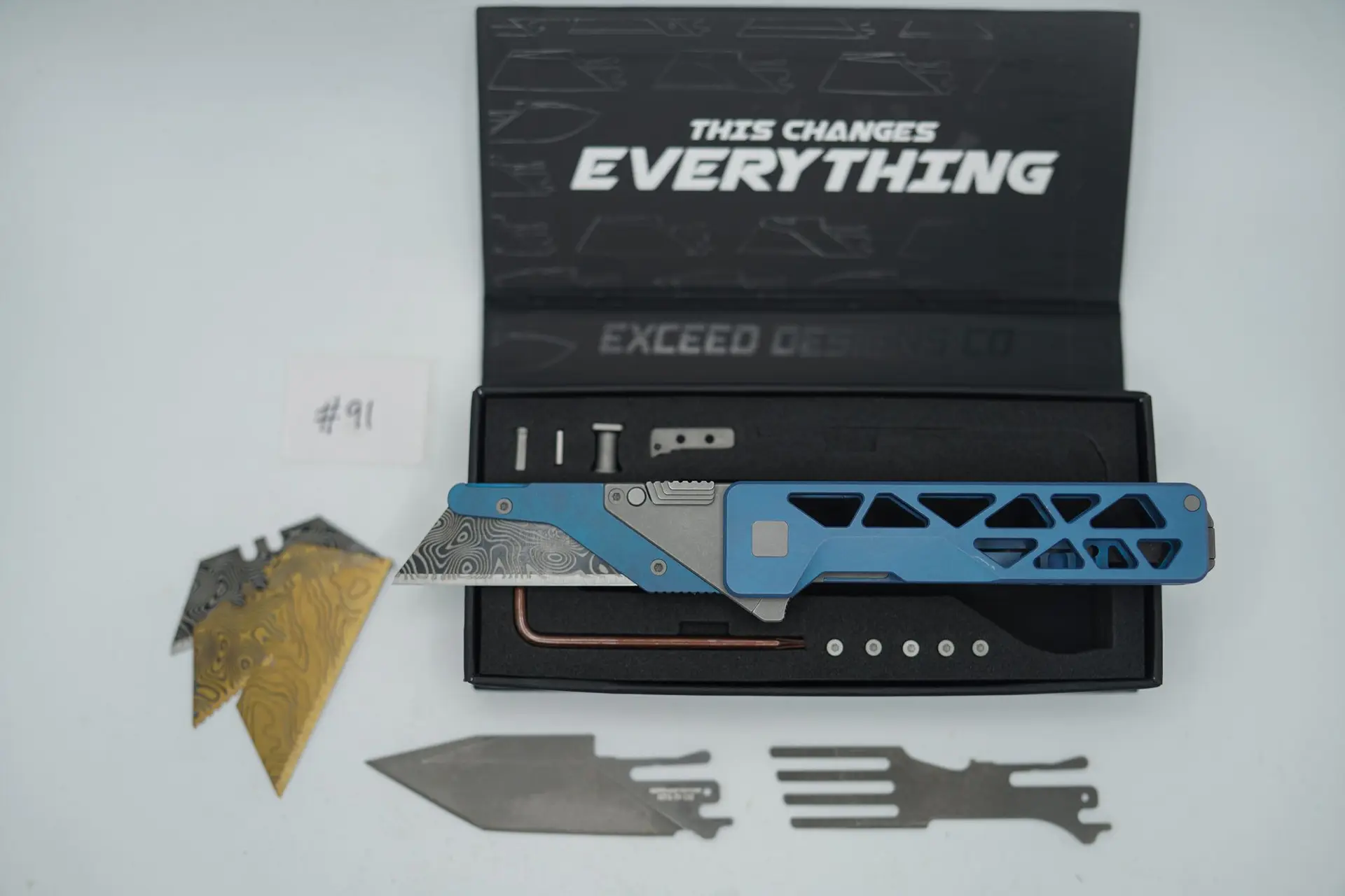 BUILD #91 — Condition 8/10 — TiRant ULTRA Skeleton ‘SKULTRA’ Aqua-BLUE Titanium ANO Applied + W/Grey Blasted Hardware + Original Box W/Grey Blasted Hardware Kit / Lock Bar insert + Blem Prototype Grind Titanium Fork Hotswap Insert + Blem D2 Stonewash Tanto Hotswap Blade + RARE Aqua-Blue ANO’d Fixed Razor Holder + 4X Custom Laser Engraved Razor Blades