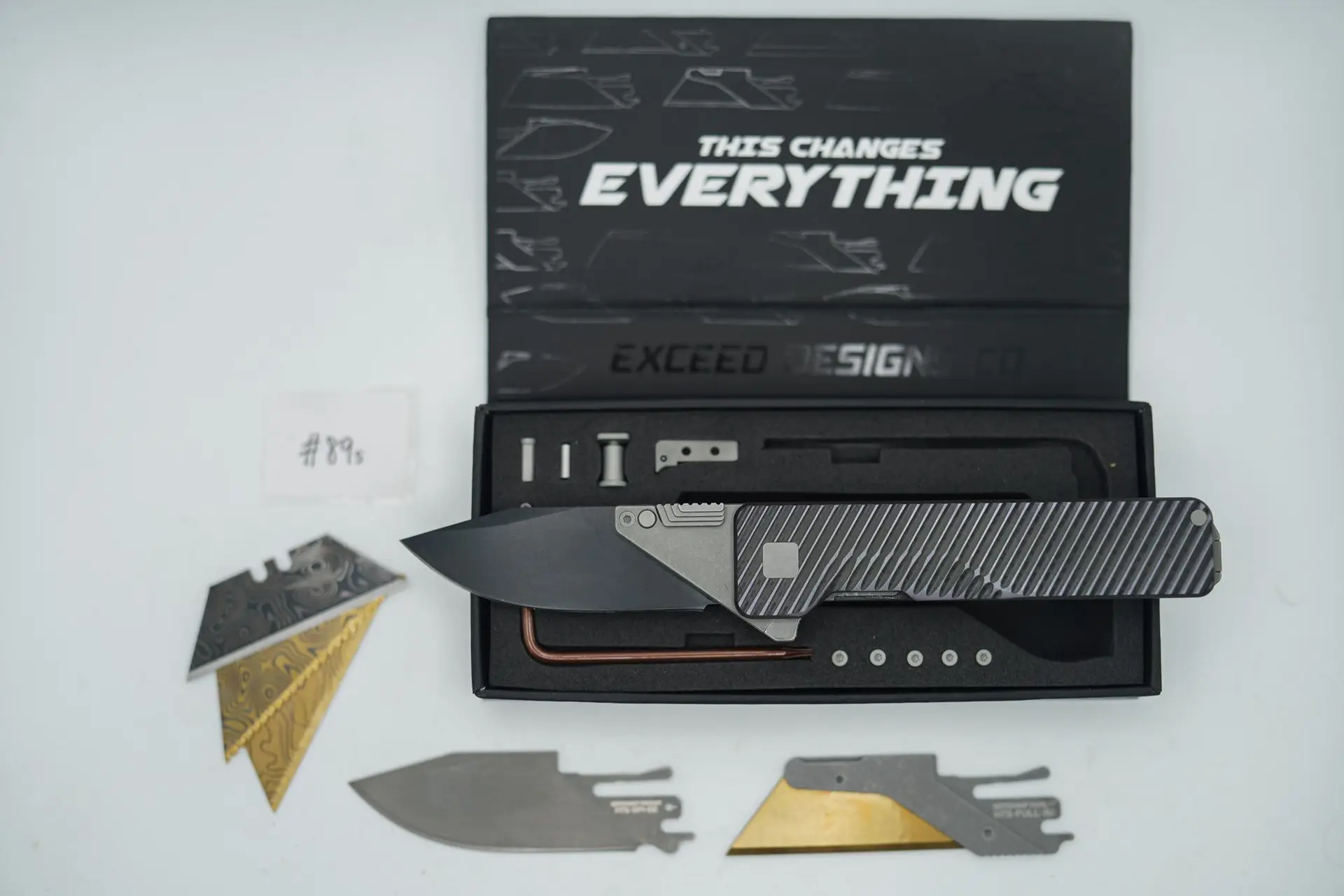 BUILD #89s — Condition 8/10 — TiRant ULTRA Dual Jet-Black DEEP-SLASH Milling With Custom Hand Sanded-Face Rare W/Light Purple ANO + SKIFF Bearings Pre-installed + W/Blasted Grey Hardware + Original Box W/Spare Grey Blasted Hardware Kit / Lock Bar insert + D2 Jet-Black Drop Point Hotswap Blade + D2 Stonewashed Drop Point Hotswap Blade + 3X Custom Laser Engraved Razor Blades