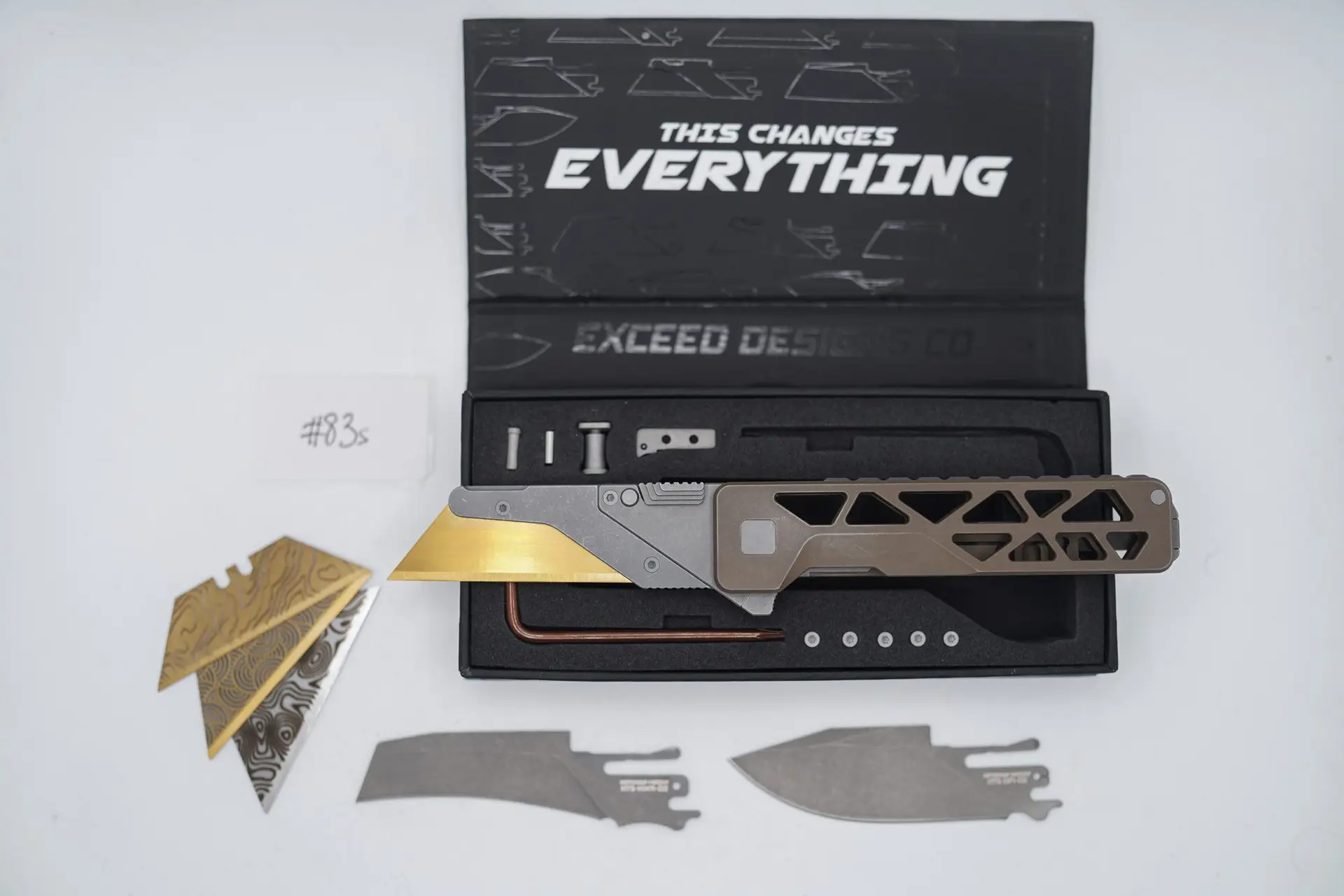 BUILD #83s — Condition 8/10 — TiRant ULTRA Skeleton ‘SKULTRA’ Centurion Bronze W/Blasted Grey Hardware + Original Box W/Spare Grey Blasted Hardware Kit / Lock Bar insert + Pre-Installed SKIFF Bearings + FULL-FRAG Stonewashed Dark Grey Ti Backspacer + D2 Stonewashed Hawkbill Hotswap Blade + D2 Stonewashed Drop Point Hotswap Blade + 3X Custom Laser Engraved Razor Blades